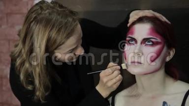 化妆师将化妆应用于模特。 万圣节化妆的漂亮模特女孩